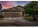 Charming home featuring a three-car garage, lush landscaping, and inviting curb appeal at sunset at 5660 S Eaton St, Littleton, CO 80123
