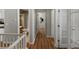 Upstairs hallway with wood floors and white trim, leading to various rooms at 5660 S Eaton St, Littleton, CO 80123