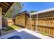 Cozy backyard area featuring a wooden fence, covered patio, and a small patch of artificial turf at 3750 S Fairplay Way, Aurora, CO 80014
