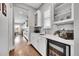 Stylish wet bar area with a wine fridge, white cabinetry, and modern fixtures at 27655 E Moraine Dr, Aurora, CO 80016