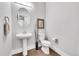 Modern powder room featuring a pedestal sink and wood-look flooring at 27655 E Moraine Dr, Aurora, CO 80016