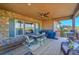 Covered patio featuring stone accents, an outdoor dining area, and a ceiling fan at 27655 E Moraine Dr, Aurora, CO 80016