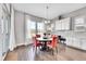 Bright dining room featuring hardwood floors, a stylish chandelier, and large windows with sheer curtains at 27655 E Moraine Dr, Aurora, CO 80016