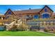 Beautiful exterior view of a grand home with stone accents, a well-manicured lawn, and a bench at 27655 E Moraine Dr, Aurora, CO 80016