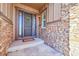 Welcoming front entrance with a decorative wreath, stone accents, and covered porch at 27655 E Moraine Dr, Aurora, CO 80016