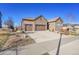 Lovely stone home with a three-car garage and well-maintained landscaping, showcasing curb appeal at 27655 E Moraine Dr, Aurora, CO 80016