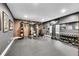 This workout room features a full weight set, striking dummy, and brick accent wall at 27655 E Moraine Dr, Aurora, CO 80016