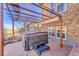 Outdoor hot tub on a patio with a pergola and stone accents at 27655 E Moraine Dr, Aurora, CO 80016