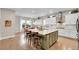Bright kitchen featuring a large island, white cabinets, modern appliances, and adjacent dining area at 27655 E Moraine Dr, Aurora, CO 80016
