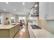 Bright kitchen featuring a large island, white cabinets, sleek countertops, stainless steel appliances and dining area at 27655 E Moraine Dr, Aurora, CO 80016