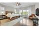 Bright main bedroom featuring tray ceiling, hardwood floors, and an abundance of natural light at 27655 E Moraine Dr, Aurora, CO 80016