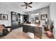 Well-appointed home office with custom built-ins, hardwood floors, and a comfortable seating area at 27655 E Moraine Dr, Aurora, CO 80016