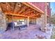 Inviting covered patio with stone pillars, wood ceiling, swing, and stamped concrete flooring at 27655 E Moraine Dr, Aurora, CO 80016