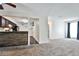 Bright living room with neutral carpet, breakfast bar, ceiling fan, and direct access to the kitchen at 7185 S Gaylord St # A, Littleton, CO 80122