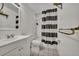 Bathroom with a tub, white subway tile, black and white stripped shower curtain and tiled floor at 2279 S Lewiston St, Aurora, CO 80013