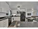 Efficient kitchen with white cabinetry, sleek black appliances, and modern lighting at 2279 S Lewiston St, Aurora, CO 80013