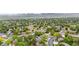This aerial view showcases a peaceful neighborhood with well-spaced houses, greenery, and scenic surroundings at 13052 W Asbury Pl, Lakewood, CO 80228