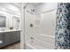 Bathroom boasts a modern vanity with a sink, decorative mirror and tiled shower with blue patterned shower curtain at 13052 W Asbury Pl, Lakewood, CO 80228