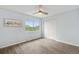 Bright empty bedroom features a ceiling fan, updated flooring, closet space and a large window at 13052 W Asbury Pl, Lakewood, CO 80228