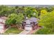 Well-maintained two-story home with a brick and tudor exterior, set on a green lawn with mature trees at 13052 W Asbury Pl, Lakewood, CO 80228