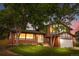 Charming two-story brick home with well-maintained lawn and mature trees in the evening at 13052 W Asbury Pl, Lakewood, CO 80228