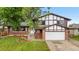 Charming two-story home featuring a brick and tudor exterior, attached garage, and a well-kept lawn at 13052 W Asbury Pl, Lakewood, CO 80228