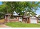 Charming two-story brick home with well-maintained lawn and mature trees on a sunny day at 13052 W Asbury Pl, Lakewood, CO 80228