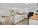 Open-concept kitchen and living area featuring an island and stainless steel appliances, with natural light at 13052 W Asbury Pl, Lakewood, CO 80228