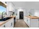 Bright modern kitchen featuring butcher block counters, white cabinets and black appliances and fixtures at 13052 W Asbury Pl, Lakewood, CO 80228
