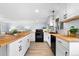 Bright kitchen featuring white cabinets, butcher block countertops, black appliances, and stylish fixtures at 13052 W Asbury Pl, Lakewood, CO 80228