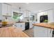 Bright kitchen with butcher block countertops, white cabinets, modern appliances, and a view of the backyard at 13052 W Asbury Pl, Lakewood, CO 80228