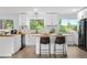 Bright, modern kitchen with butcher block countertops, an island with seating, and views of the backyard at 13052 W Asbury Pl, Lakewood, CO 80228