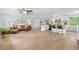 Open-concept living room with a large kitchen island, wood floors, and a comfortable seating area at 13052 W Asbury Pl, Lakewood, CO 80228