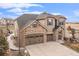 Charming two-story home featuring a stone and stucco facade, attached garage, and well-manicured landscaping at 2627 Hillcroft Ln, Castle Rock, CO 80104