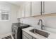 Clean and functional laundry room with modern washer and dryer, countertop space, and ample cabinet storage at 2627 Hillcroft Ln, Castle Rock, CO 80104