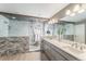 This spa-like main bathroom features double sinks, a glass enclosed shower, and stone accent walls at 2627 Hillcroft Ln, Castle Rock, CO 80104