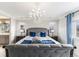 A luxurious main bedroom showcasing a chandelier, side tables, neighborhood views and plush bedding at 2627 Hillcroft Ln, Castle Rock, CO 80104