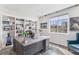 Bright home office with built-in shelving, a spacious desk, and a large window overlooking the neighborhood at 2627 Hillcroft Ln, Castle Rock, CO 80104