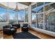 Bright sunroom with water views features a chandelier, hardwood floors, and comfortable leather armchairs at 6040 W Prentice Ave, Littleton, CO 80123