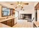 Functional kitchen area with tile flooring, wood cabinetry, and an open view of the sunken living room at 7009 S Forest Ct, Centennial, CO 80122