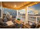 Inviting covered back porch with comfortable seating, string lights, and a peaceful neighborhood view at 19973 W 94Th Ln, Arvada, CO 80007