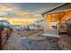 Landscaped backyard with a covered porch, cozy seating area, and beautiful sunset views at 19973 W 94Th Ln, Arvada, CO 80007