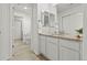 Bright bathroom featuring a double sink vanity with granite countertops and white cabinetry at 19973 W 94Th Ln, Arvada, CO 80007