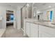 Bright bathroom featuring double sinks, granite countertops, and a glass-enclosed shower at 19973 W 94Th Ln, Arvada, CO 80007