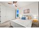 Bright bedroom featuring a ceiling fan, carpet flooring, a white bed frame, and two windows with exterior views at 19973 W 94Th Ln, Arvada, CO 80007