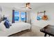Well-lit bedroom featuring decorative guitars, white linens, and large windows with blue patterned curtains at 19973 W 94Th Ln, Arvada, CO 80007