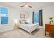 Comfortable bedroom featuring a ceiling fan, a white bed frame, two windows with blue exterior views, and carpeted floors at 19973 W 94Th Ln, Arvada, CO 80007