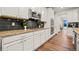 Modern kitchen featuring white cabinetry, stainless steel appliances, granite countertops, and stylish black subway tile backsplash at 19973 W 94Th Ln, Arvada, CO 80007