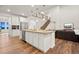 Open concept kitchen featuring a large island with sink and dishwasher, white cabinets, and an adjacent living space at 19973 W 94Th Ln, Arvada, CO 80007