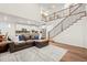 Open-concept living space with a staircase, modern furnishings, and an adjoining kitchen area at 19973 W 94Th Ln, Arvada, CO 80007